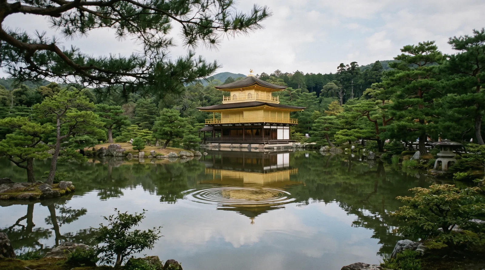 Gold leaf on the upper storeys of Kinkaku-ji mirrored in the still pond at 09:10, Kyoto Japan