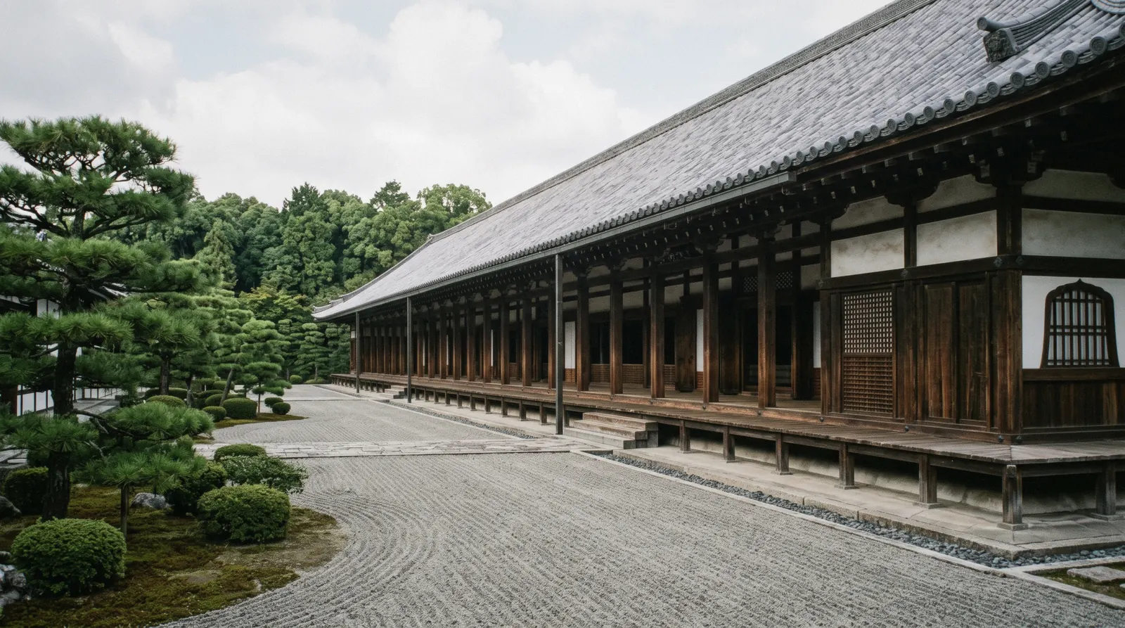 The long low roofline of the Sanjusangen-do hall stretching away behind its garden wall, Kyoto Japan