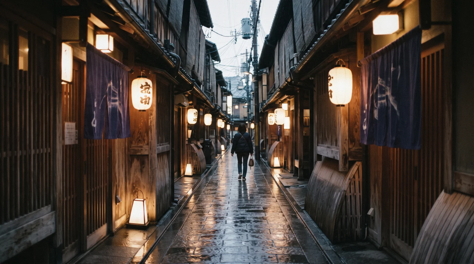 A narrow lantern-lit restaurant alley with wooden fronts in the evening, where to eat in Kyoto Japan
